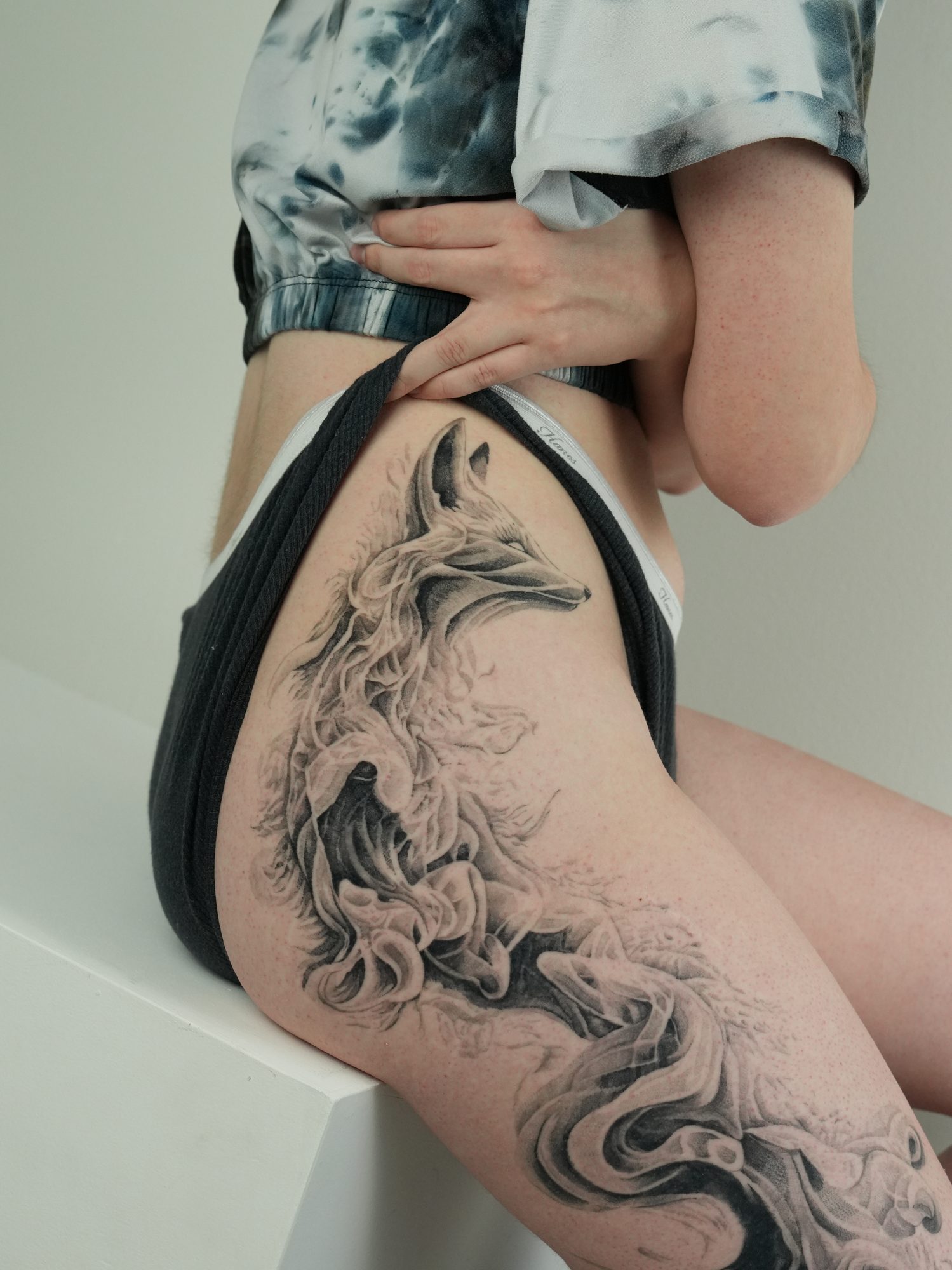 Detail of the smoke fox tattoo — the fox's face forming out of black and grey smoke